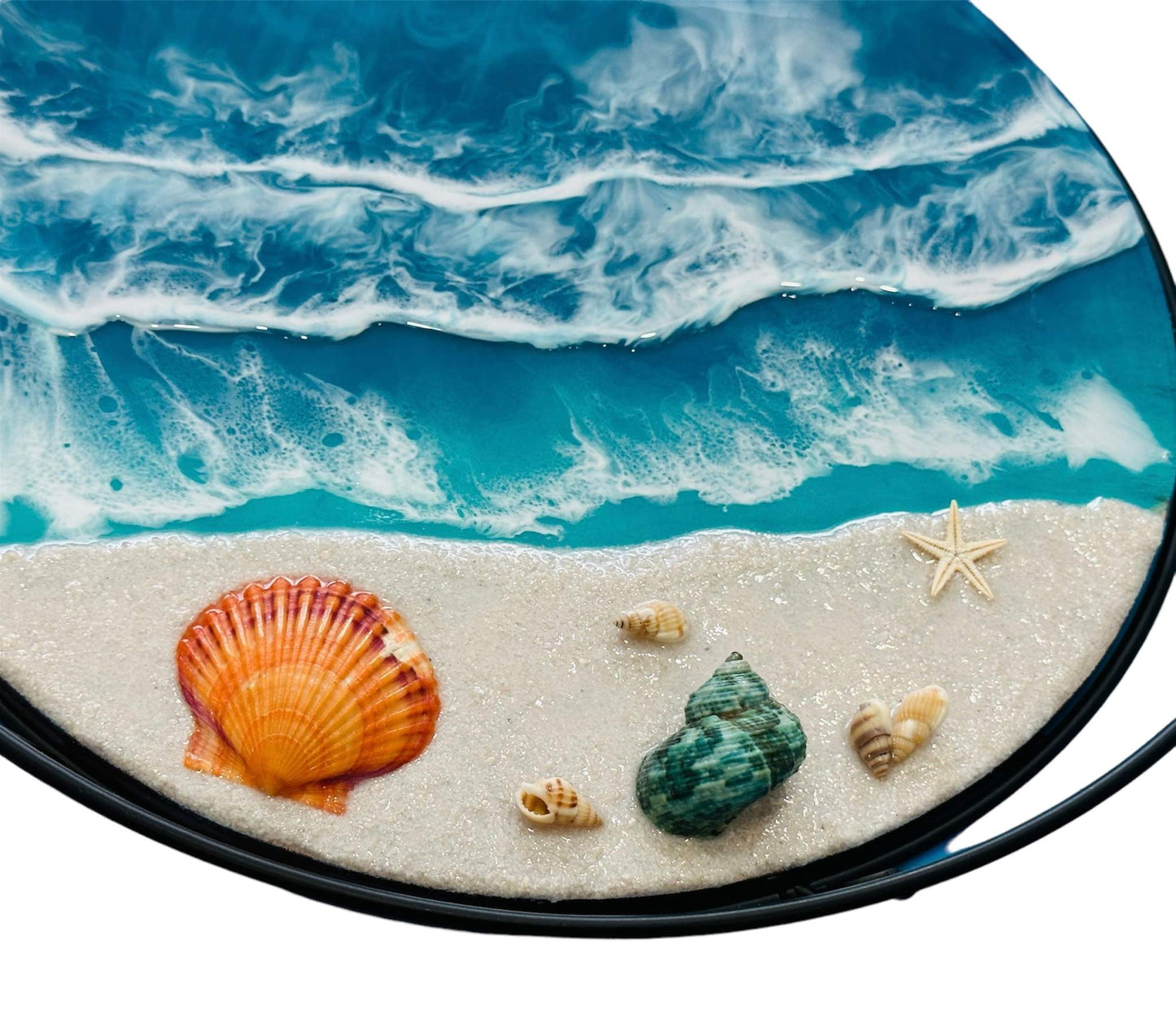 Close-up of a metal frame tray with ocean wave patterns, detailed seashells, and a starfish on a sandy beach design.