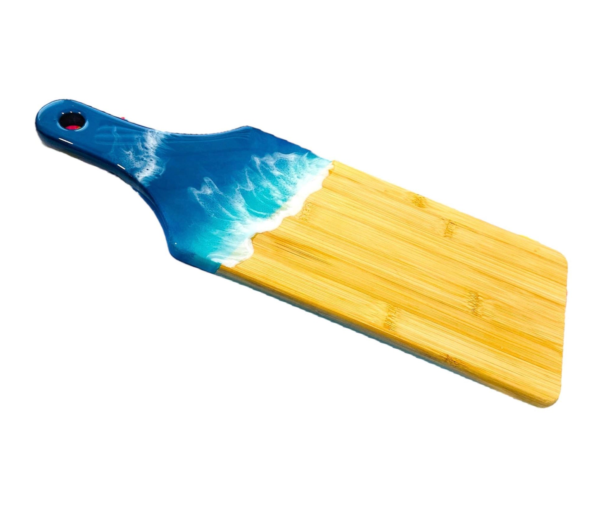 Ocean wave resin cheese board with handcrafted bamboo base and ocean-inspired resin art featuring layered blues and white foam.