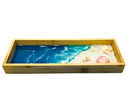 Wooden decorative tray with ocean wave design, seashells, and starfish accents in a natural wood frame