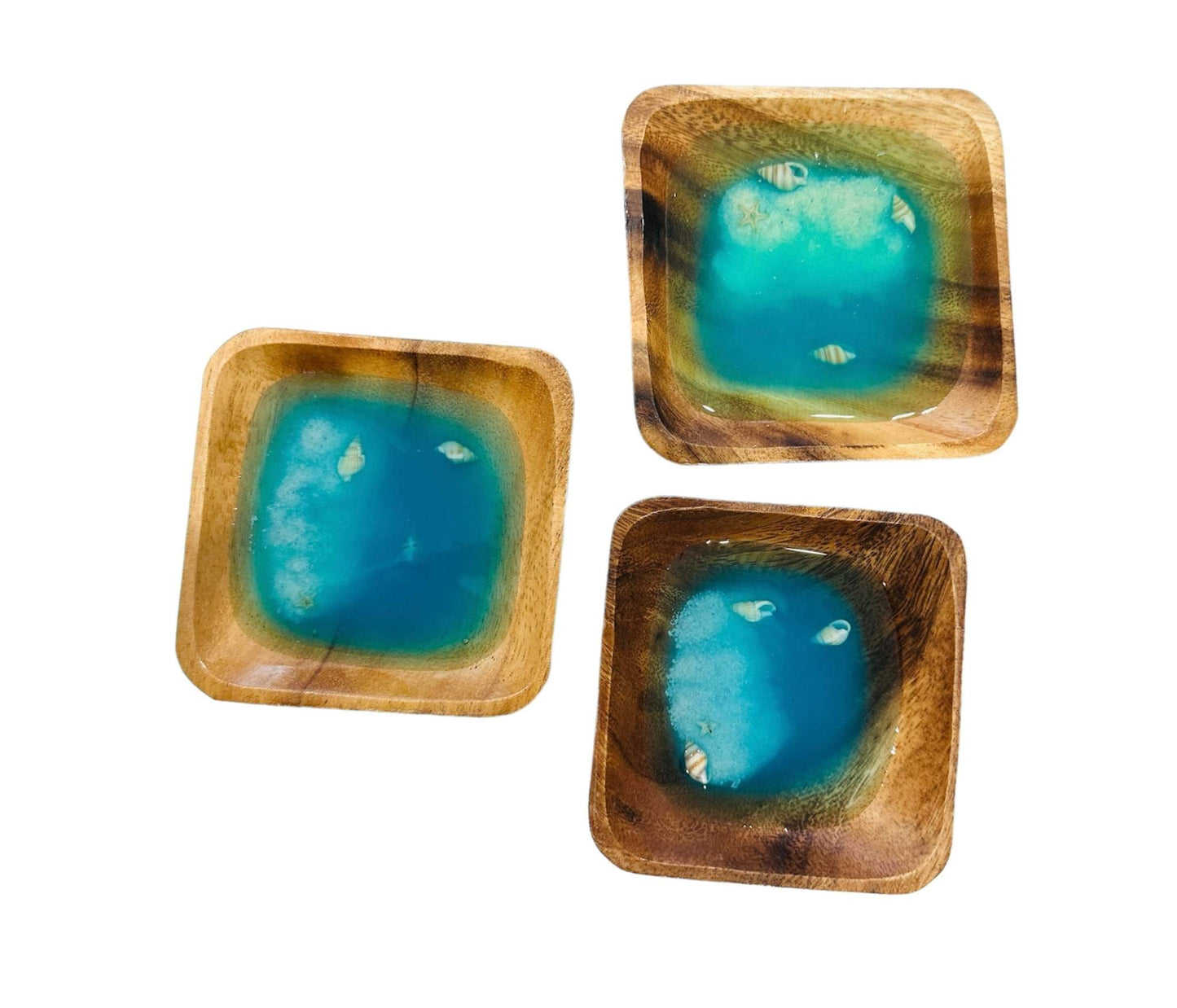 Set of three handcrafted deep sea inspired wooden jewelry plates with vibrant blue resin centers and small embedded shells