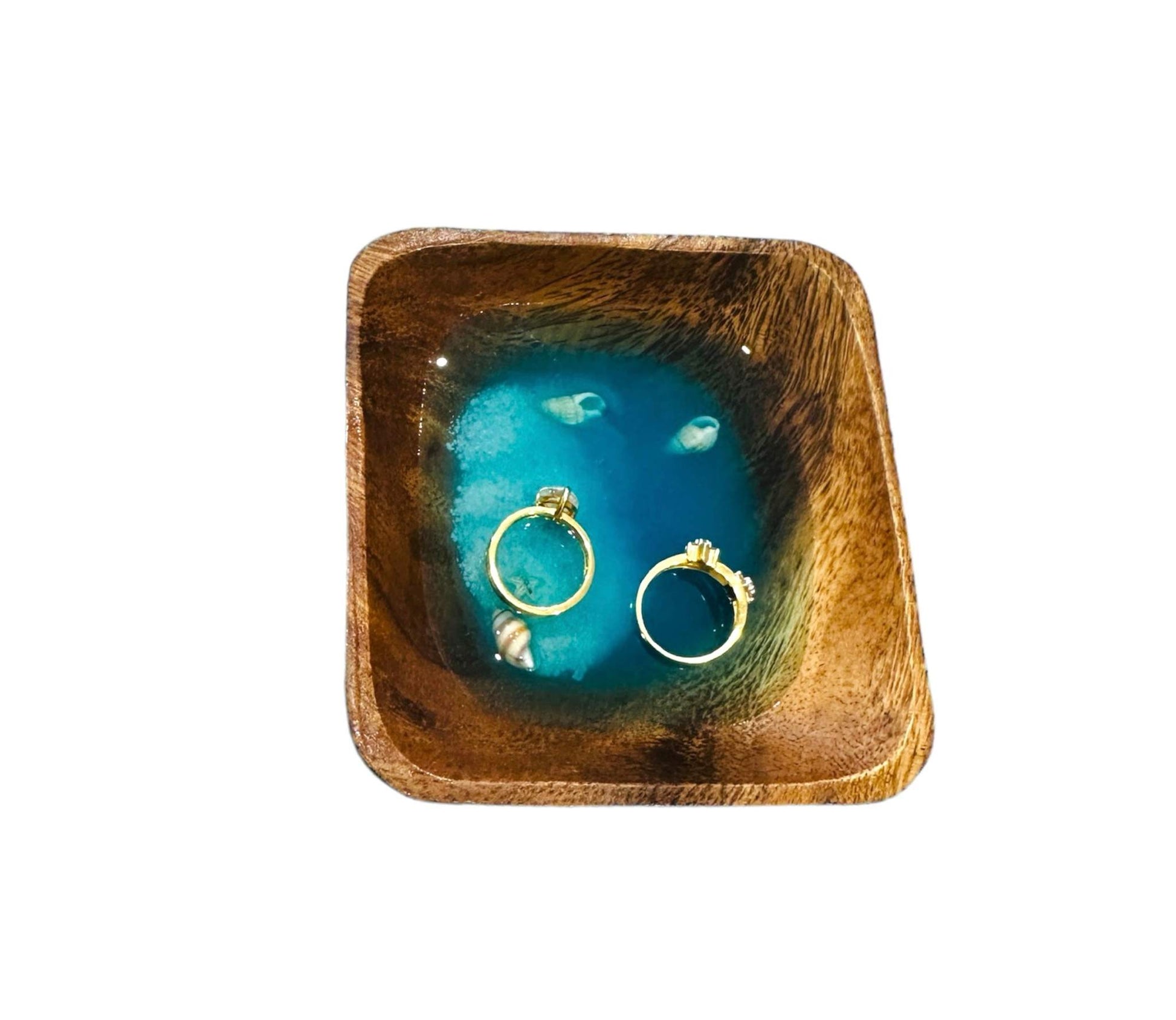 Deep sea inspired wooden jewelry plate with vibrant blue resin center holding two gold rings