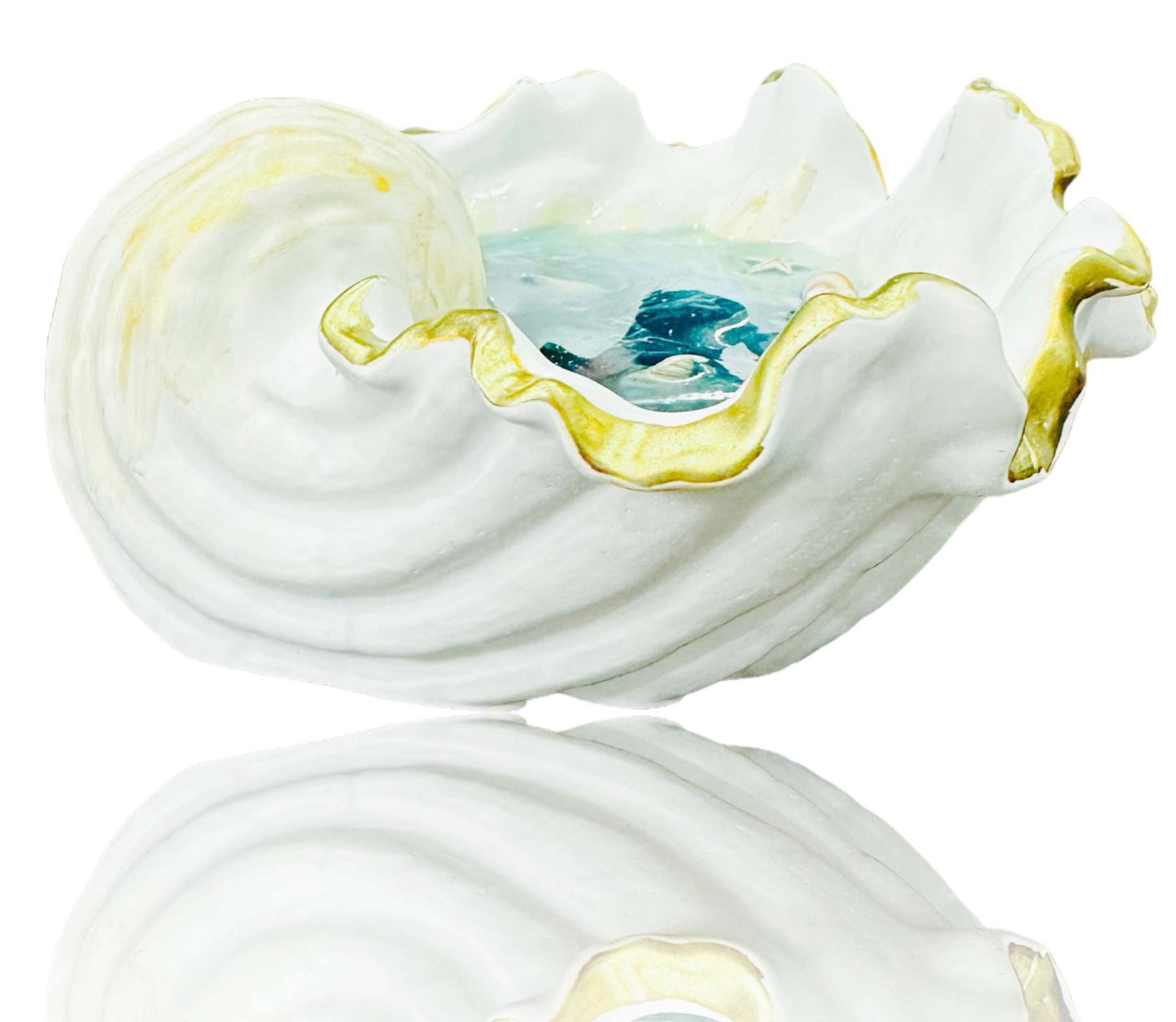 White sea shell shaped jewelry plate with gold trim and blue resin interior resembling ocean waves