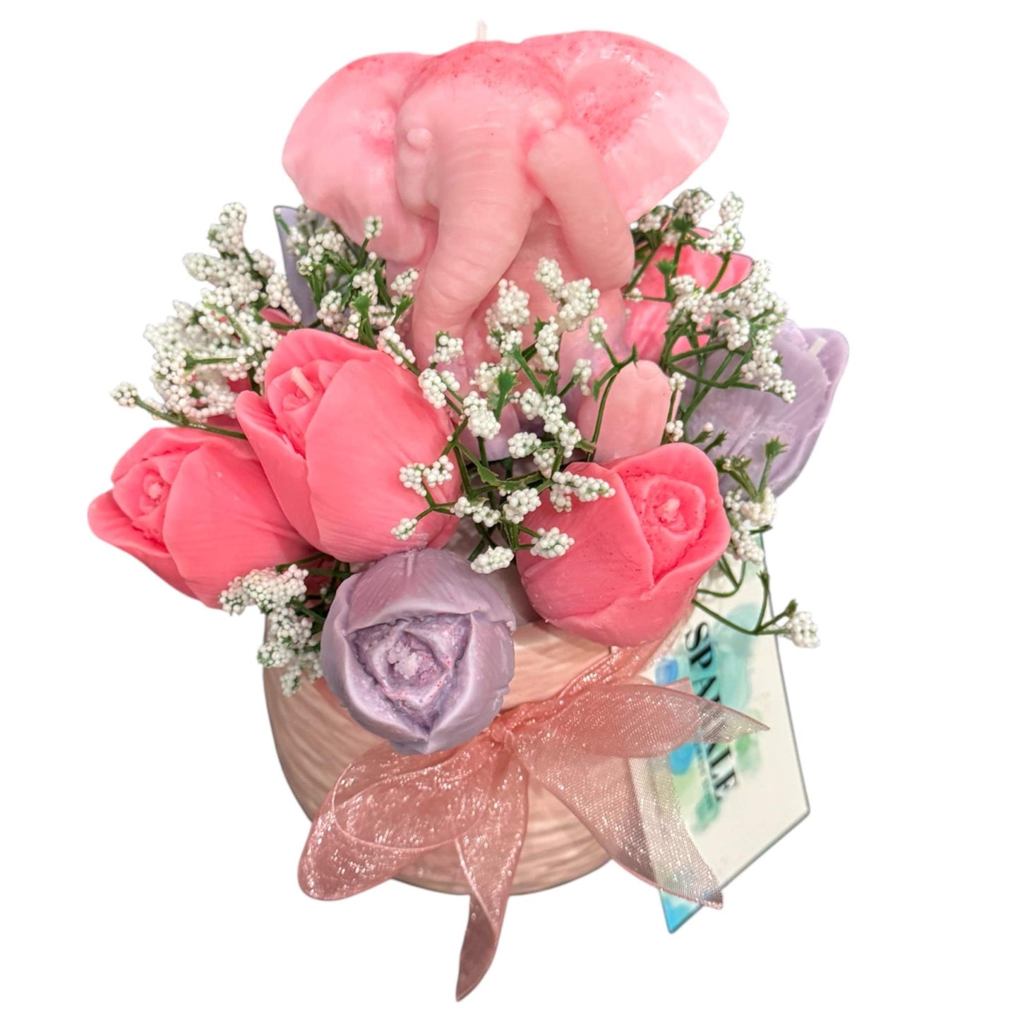 Customizable gift basket featuring pink and purple baby clothes, a cozy blanket, organic shea soap, a hand-poured candle, and a floral bouquet with an elephant decoration.