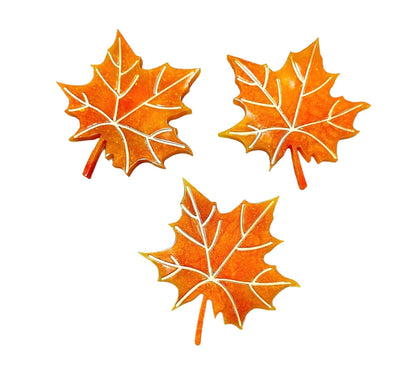 Set of three handmade maple leaf resin coasters in autumn orange color with detailed veins.