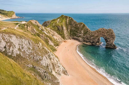 Scenic view of Durdle Door limestone arch and beach on the Jurassic Coast, England, inspiring handmade 3D coastal wall art sculpture.