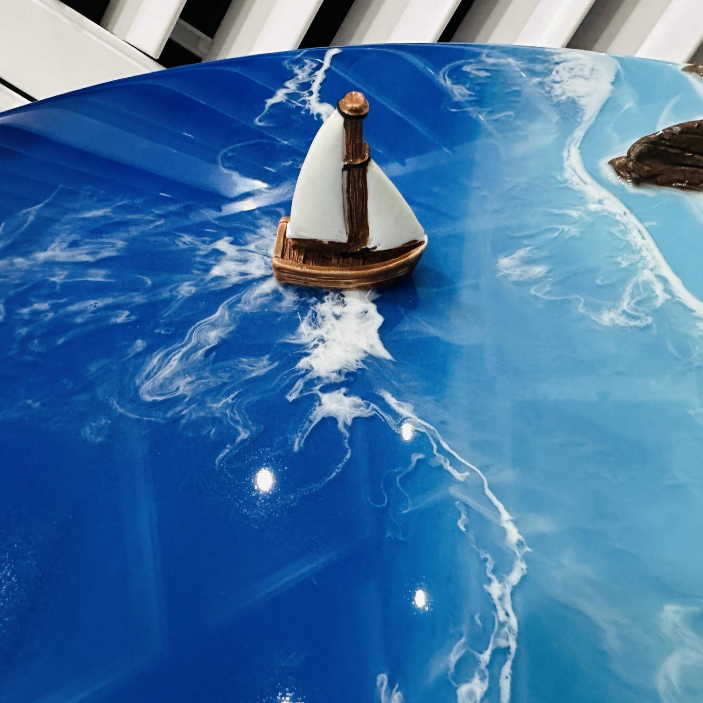 Close-up of Durdle Door UK Sculpture featuring a handmade 3D coastal wall art with a textured shark-shaped island and vibrant blue resin ocean waves.