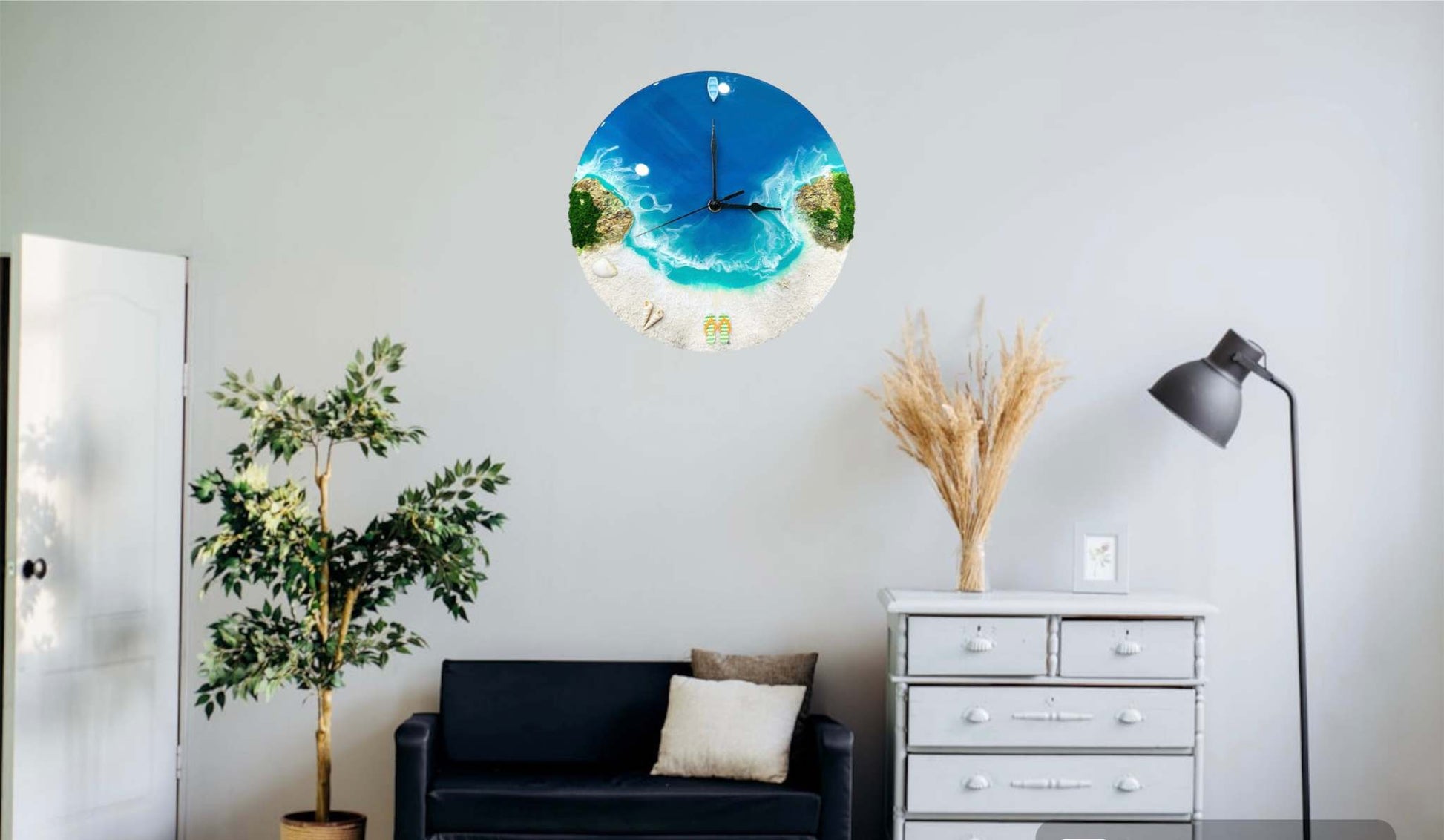 Round resin ocean wall clock featuring ocean waves, sandy beach, rocks, and miniature boat decor in a living room setting.
