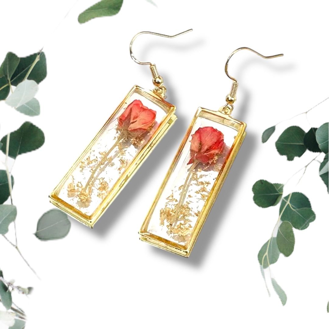 Handcrafted rectangle earrings with real dried rose petals encased in clear resin with gold frame on white background