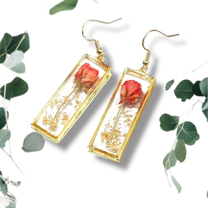 Handcrafted rectangle earrings with real dried rose petals encased in clear resin with gold frame on white background