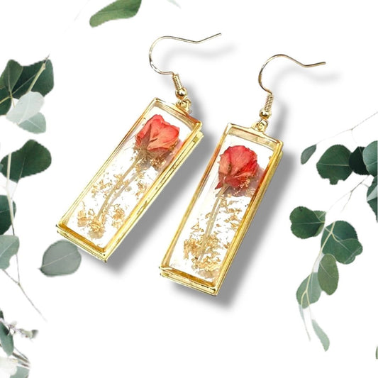 Handcrafted rectangle earrings with real dried rose petals encased in clear resin with gold frame on white background