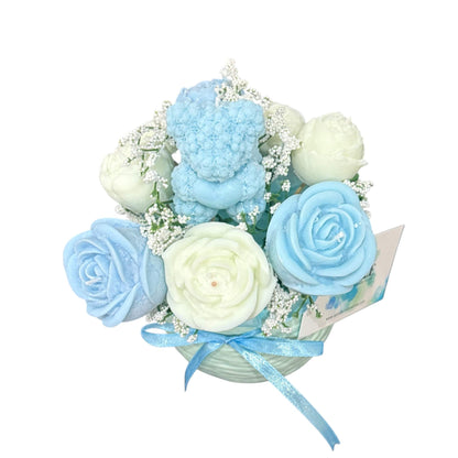 Handmade scented candle flower bouquet in blue and cream with a teddy bear candle in a decorative vase