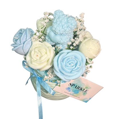 Handmade candle flower bouquet in blue and cream hues with a blue teddy bear candle in a decorative vase