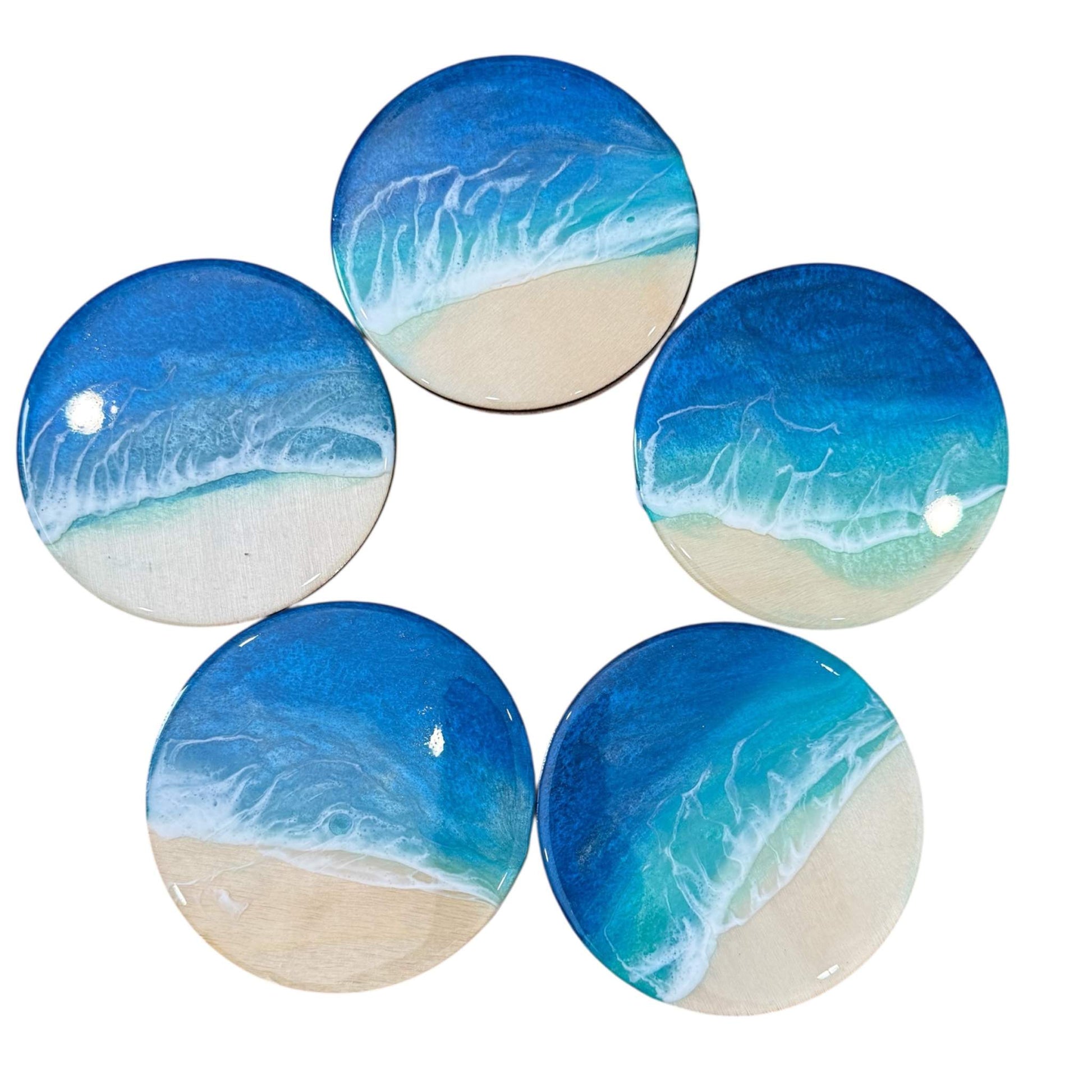 Set of five handcrafted resin ocean coasters featuring realistic beach wave designs in blue and sandy tones.