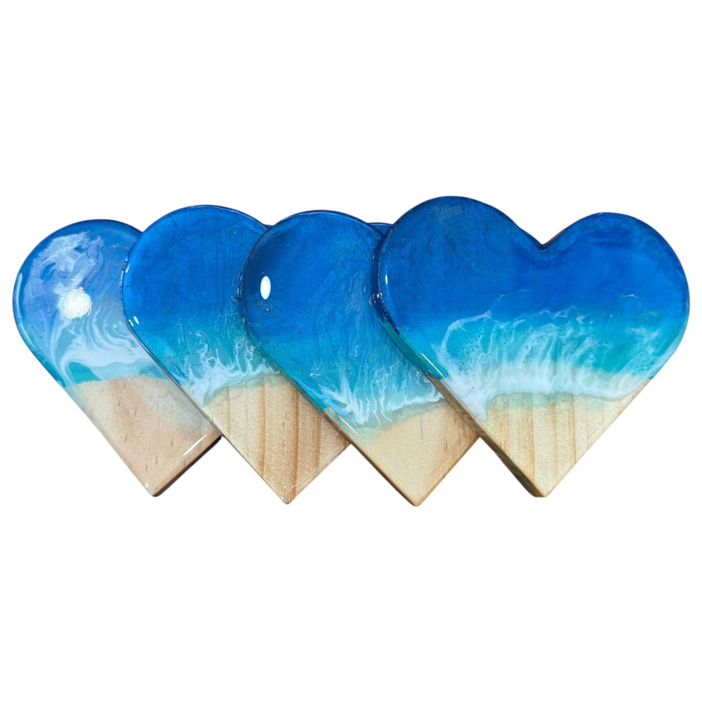 Set of heart-shaped ocean wave resin coasters with beach design and glossy finish