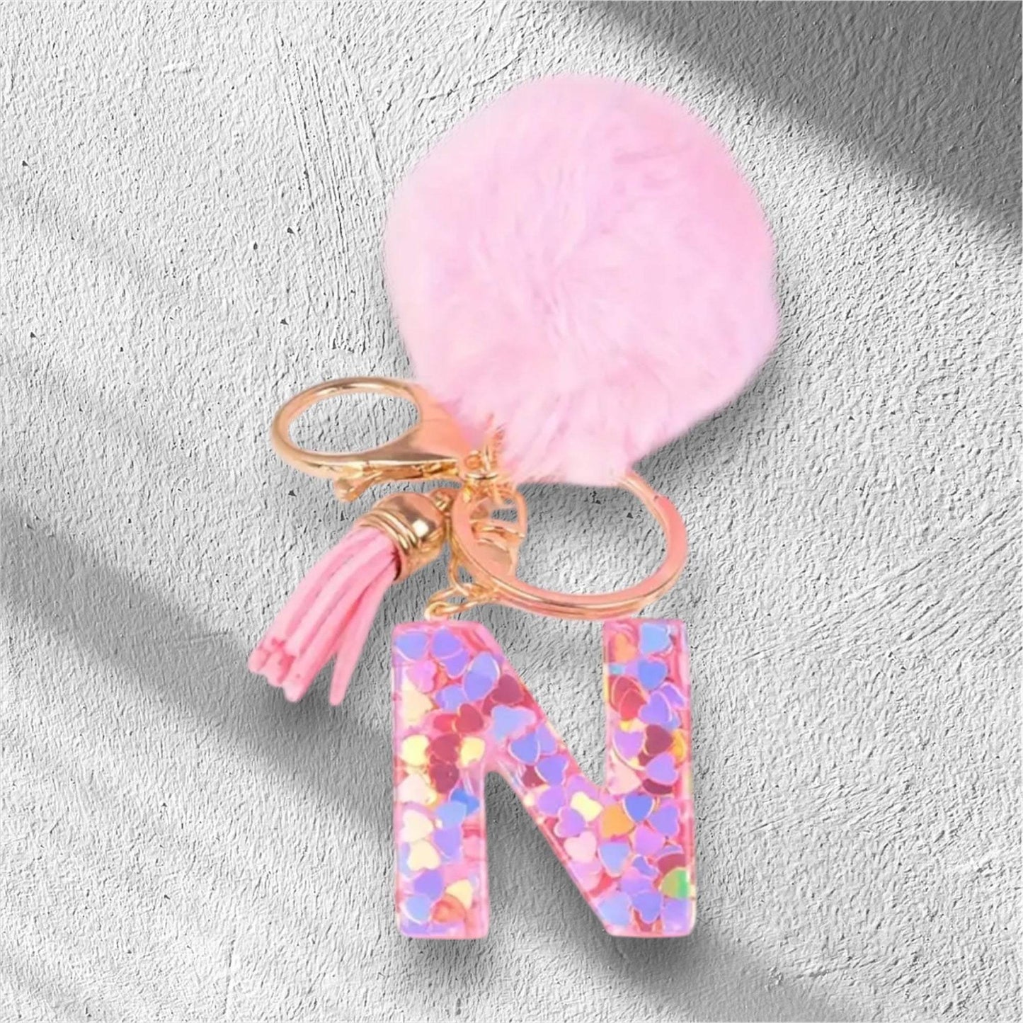 Colorful letter N alphabet keychain with pink pom-pom and tassel accessory