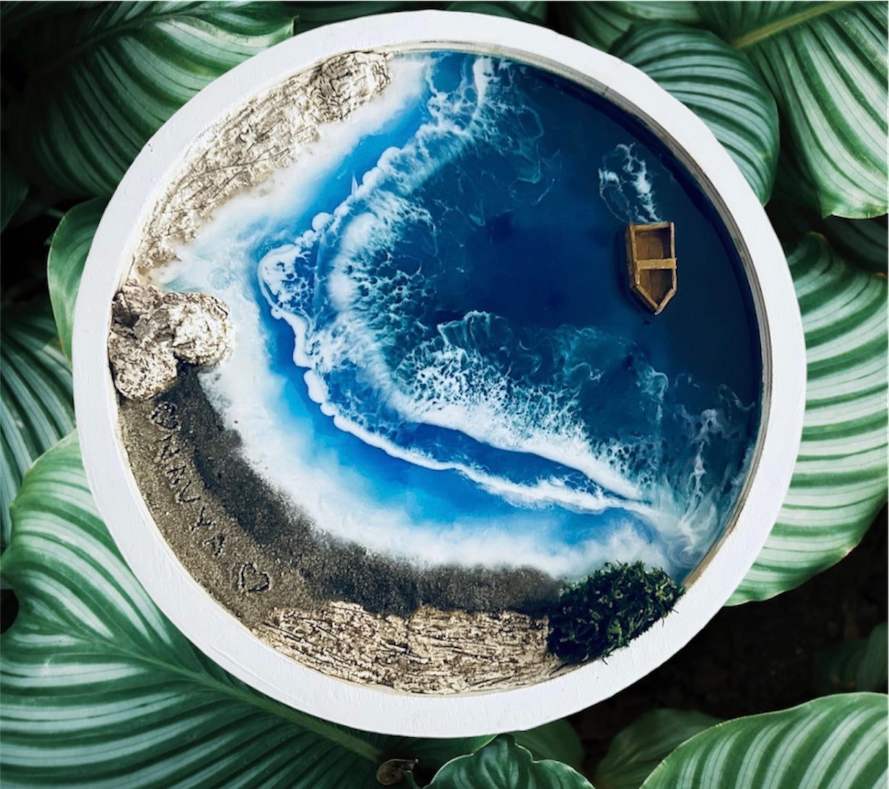 12-inch round ocean art for home decor with white frame, resin waves and beach scene including a small boat, perfect for coastal-themed interiors.