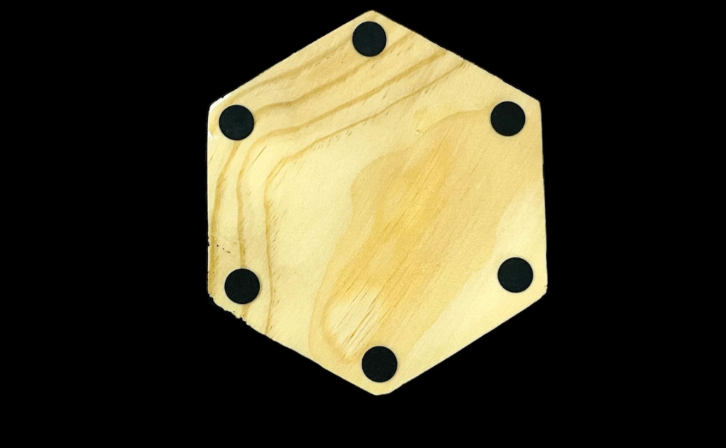 Hexagonal wooden base of a watercolor flower resin coaster with black non-slip pads.