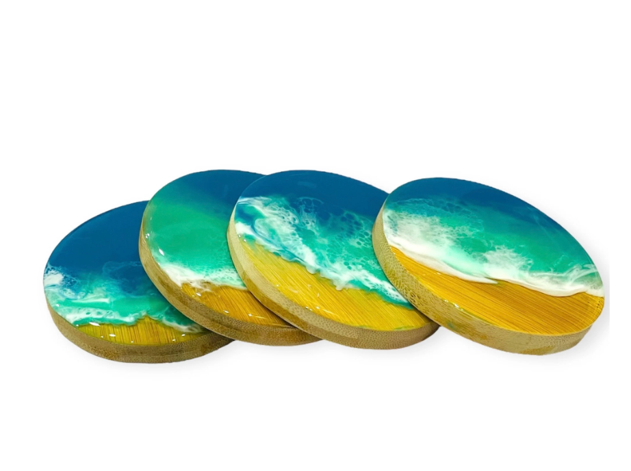 Set of 4 handmade ocean wave resin coasters with vibrant blue and turquoise epoxy resin and sandy beach design.