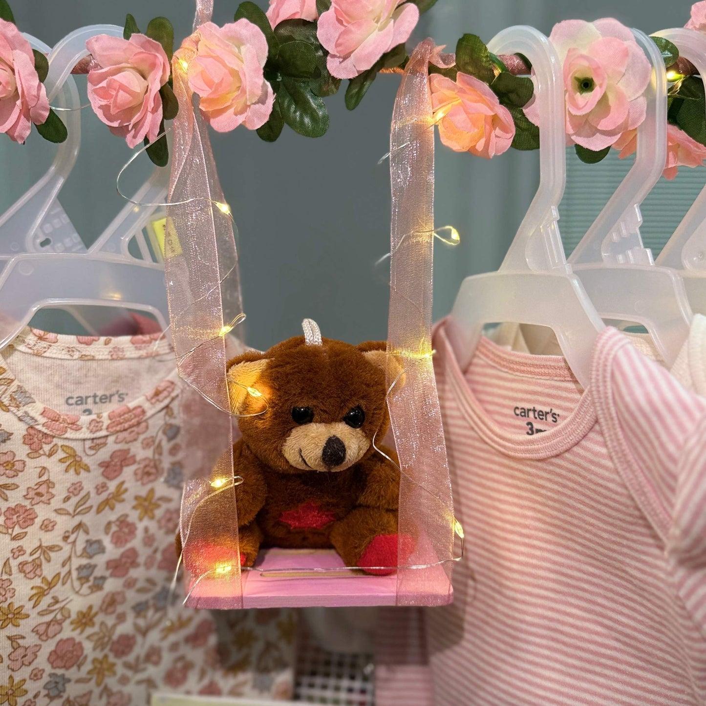 Custom baby shower gift basket with handmade newborn essentials including soft onesies, plush toy, and cozy accessories