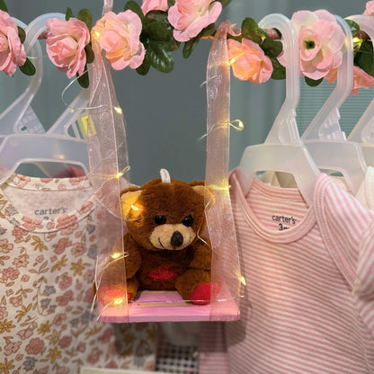 Custom baby shower gift basket with handmade newborn essentials including soft onesies, plush toy, and cozy accessories